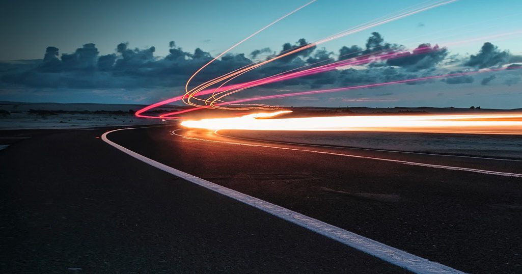 Lichter auf einer Straße am Meer bei Sonnenuntergang