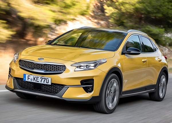 Gelber Kia X-Ceed fährt auf einer Straße