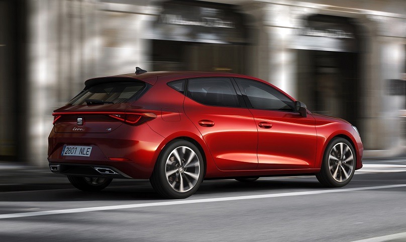 Roter Seat Leon auf der Straße mit Gebäude im Hintergrund