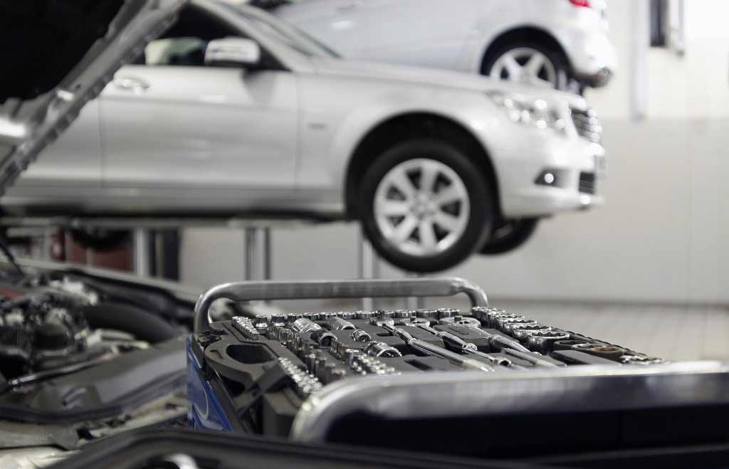 Werkzeug in einer Werkstatt mit einem aufgebocktem Auto im Hintergrund